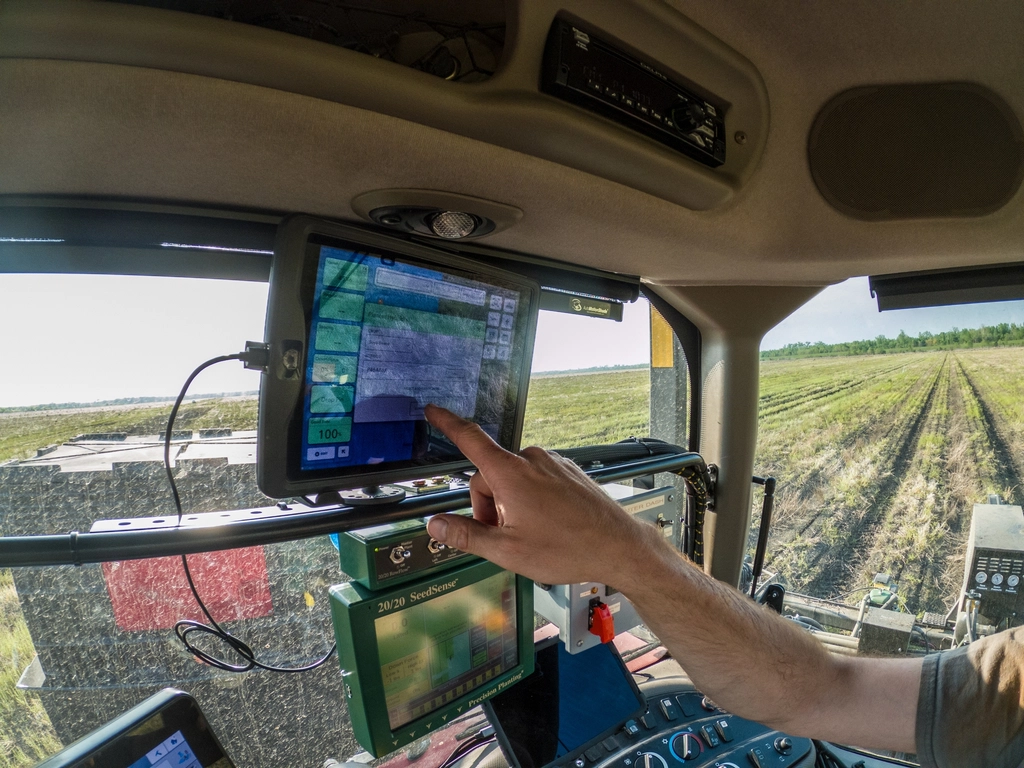 Farmer using AI-powered agriculture technology on a tablet in a field