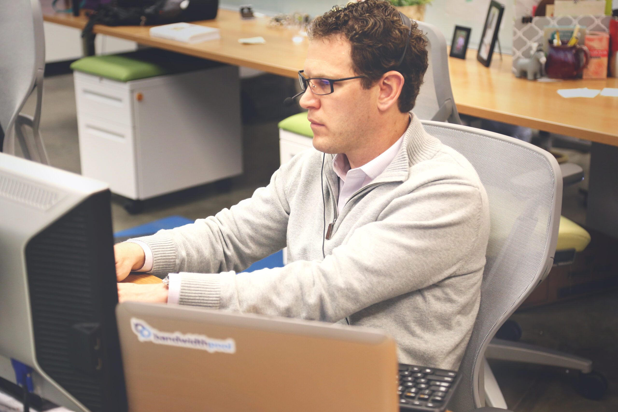 Shared office workspace with desks and laptops, illustrating how one AI job description now covers several different engineering roles