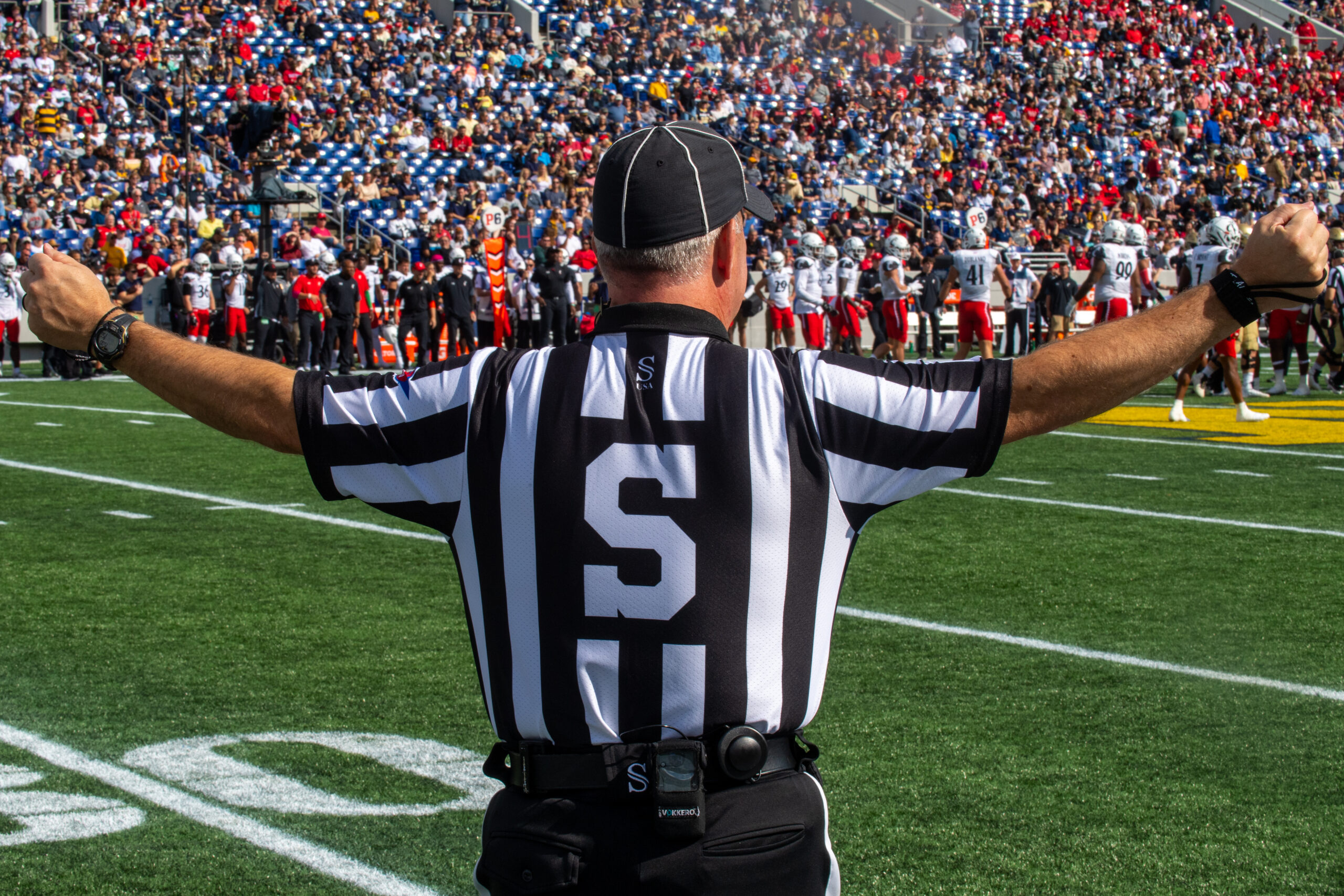 Referee on the field during a stadium match, illustrating AI referee technology in sport