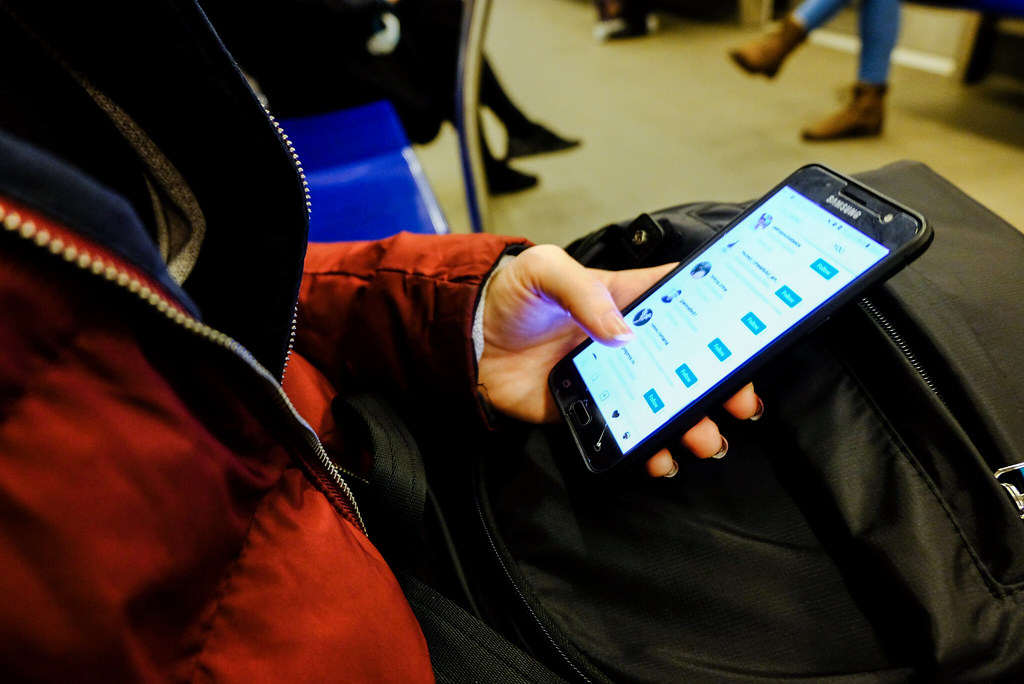 Person scrolling social media on a phone, illustrating how fake Reddit posts shape AI answers