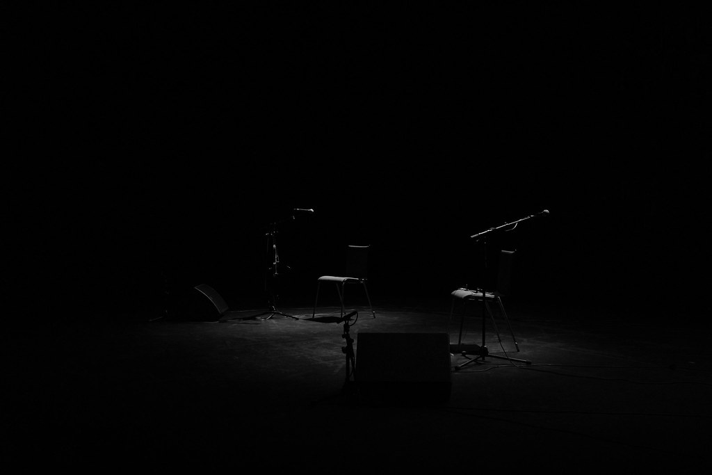 Recording studio microphones and chairs, illustrating the debate over creators who use AI