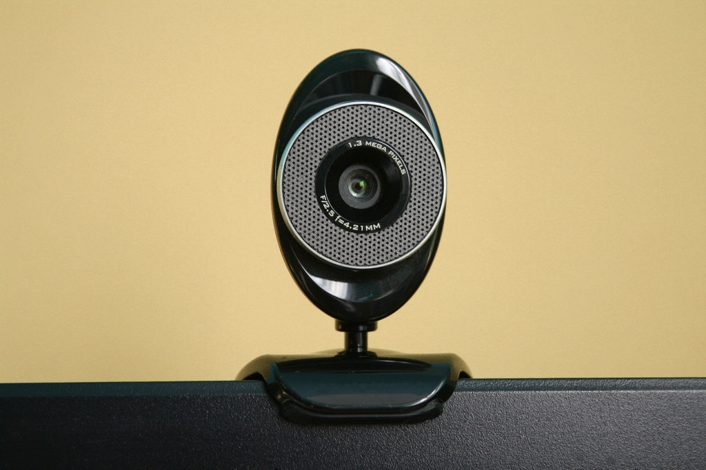 Webcam on a monitor, illustrating how to tell if a video call is an AI avatar