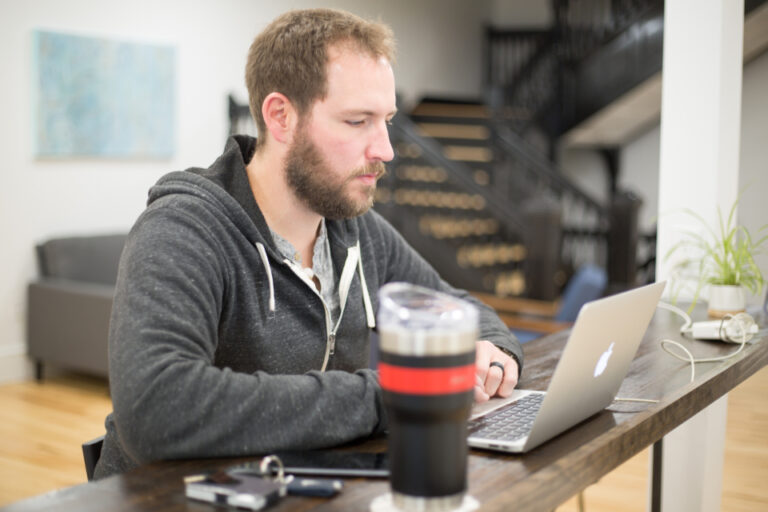Worker reading a laptop screen, illustrating the question can AI fire you under California law