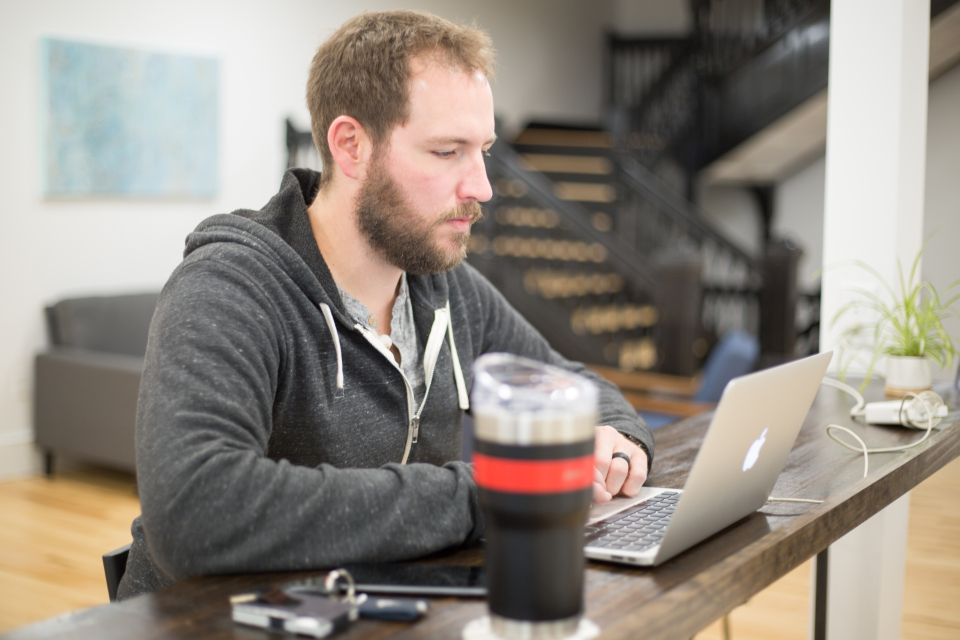 Worker reading a laptop screen, illustrating the question can AI fire you under California law
