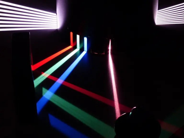 Beam of light split into colors by a glass prism, representing a light-based deepfake detector
